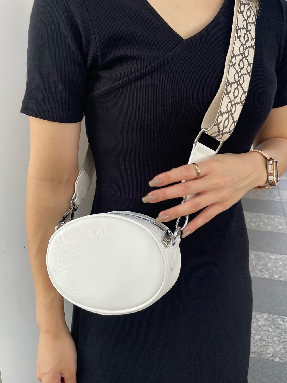 ブラック系のワンピース、ブラック系のサンダル、ホワイト系のショルダーバッグを着用したレディースの夏コーディネートの7枚目の写真