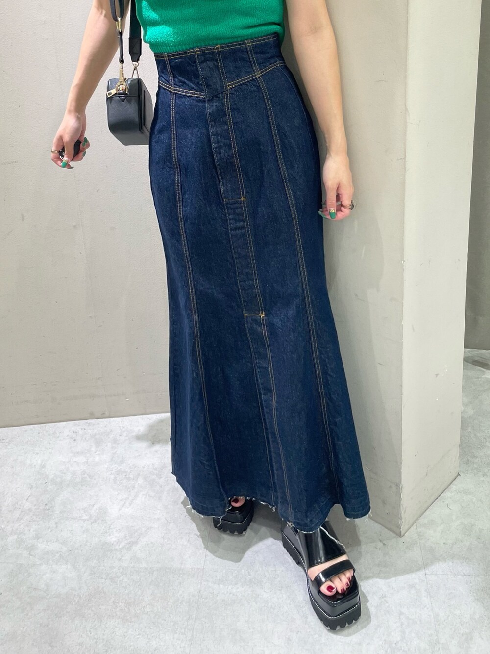 ブラック系のサンダル、ブラック系のショルダーバッグ、グリーン系のタンクトップを着用したレディースの夏コーディネートの7枚目の写真