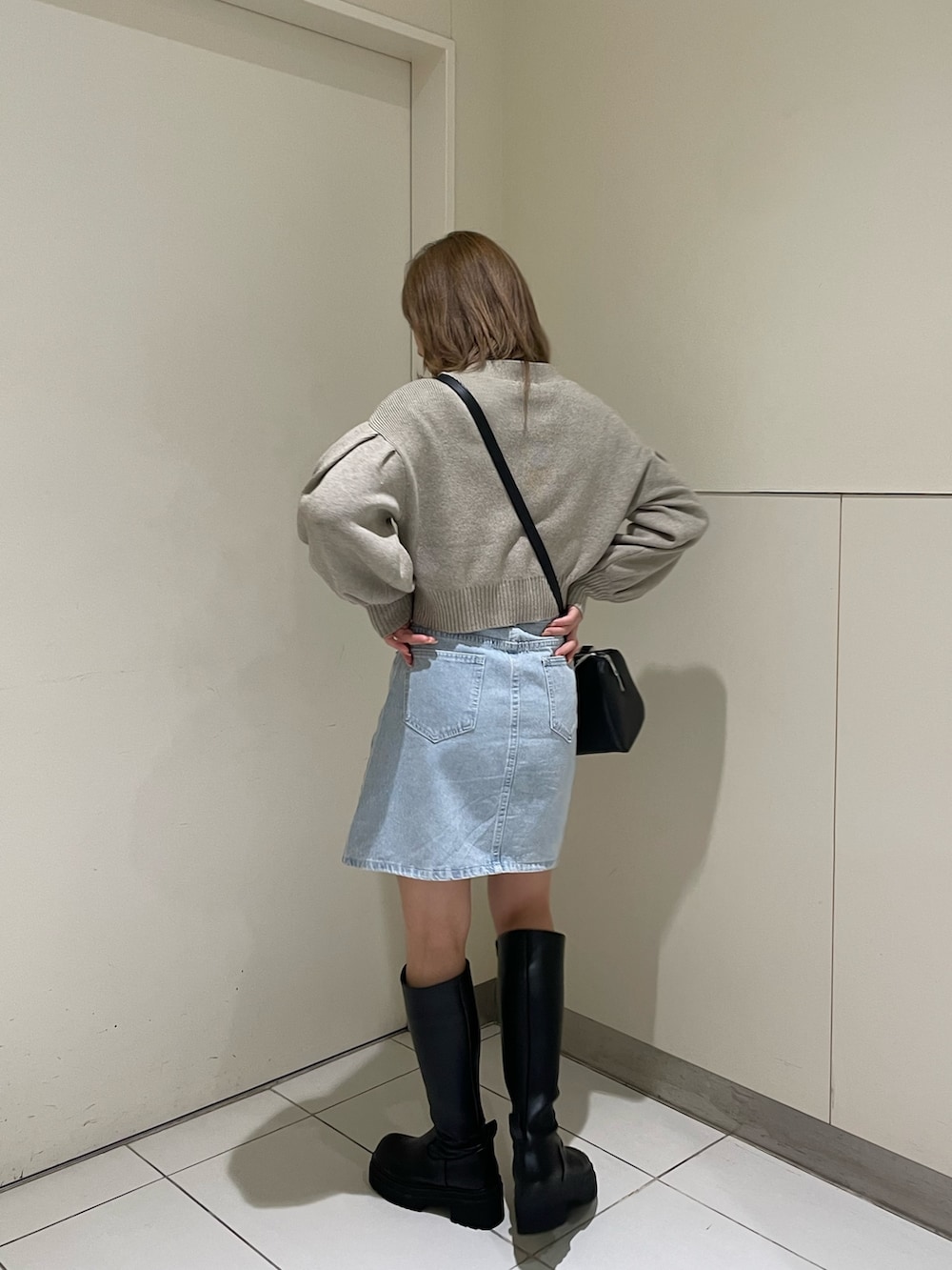 ホワイト系のカーディガン/ボレロ、ブラック系のブーツ、ブラック系のハンドバッグを着用したレディースの春コーディネートの4枚目の写真