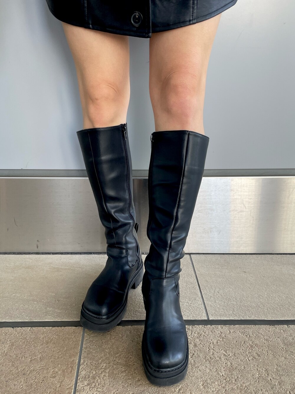 ブラック系のワンピース、ホワイト系のニット/セーター、ブラウン系のムートンコートを着用したレディースの冬コーディネートの10枚目の写真