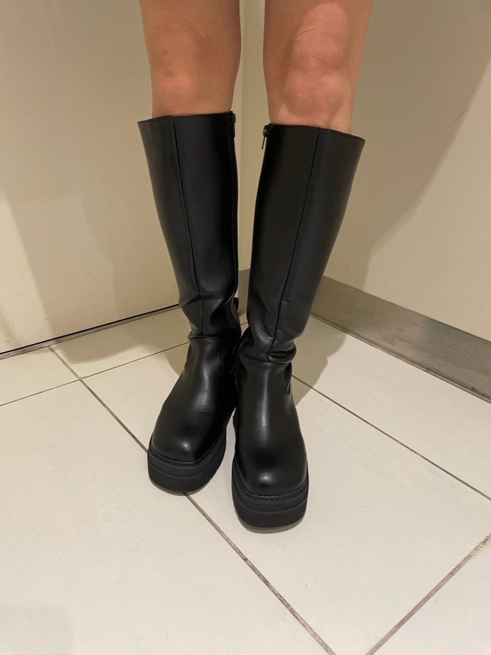 ホワイト系のカーディガン/ボレロ、ブラック系のブーツ、ブラック系のハンドバッグを着用したレディースの春コーディネートの7枚目の写真