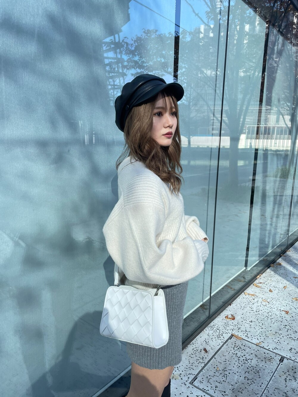 ホワイト系のニット/セーター、グレー系のスウェットパンツ、ブラック系のブーツを着用したレディースの秋コーディネートの5枚目の写真