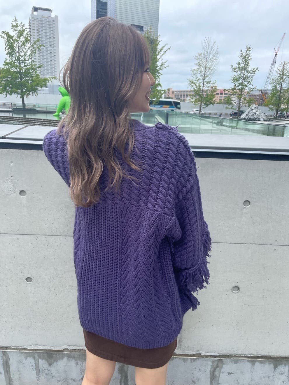 ブラウン系のスカート、ベージュ系のブーツ、パープル系のカーディガン/ボレロを着用したレディースの秋コーディネートの7枚目の写真