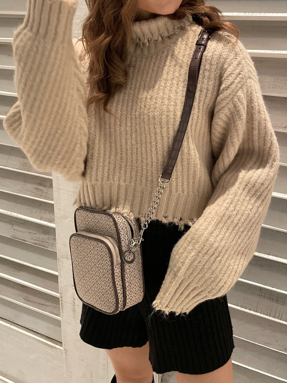 ホワイト系のニット/セーター、ブラック系のブーツ、その他のショルダーバッグを着用したレディースの秋コーディネートの8枚目の写真