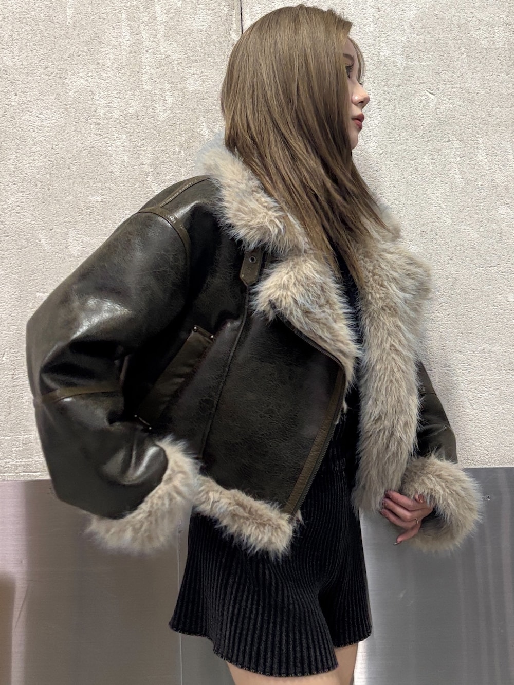 ブラック系のブーツ、ブラック系のその他パンツ、グリーン系のムートンコートを着用したレディースの秋コーディネートの9枚目の写真