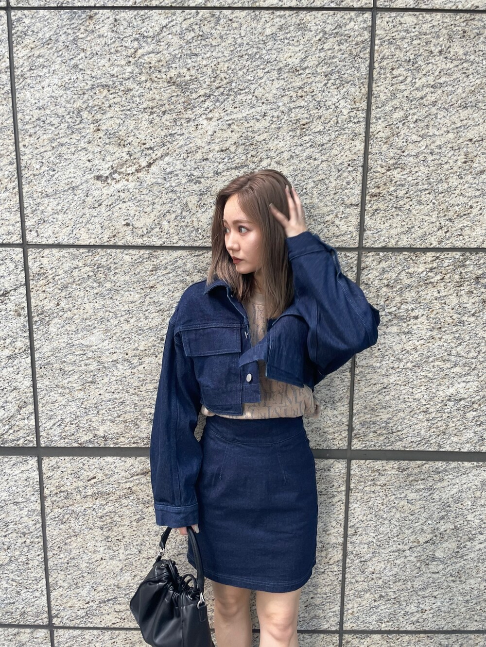 ベージュ系のニット/セーター、ブルー系のスカート、ブラック系のブーツを着用したレディースの夏コーディネートの5枚目の写真