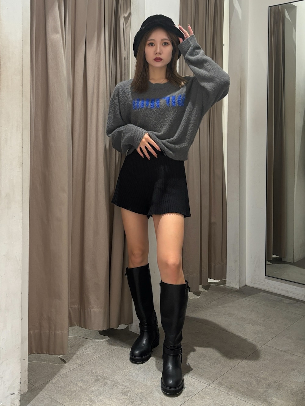 グレー系のニット/セーター、ブラック系のその他パンツ、ブラック系のブーツを着用したレディースの秋コーディネートの6枚目の写真