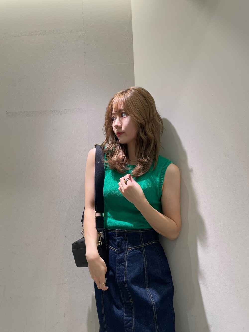 ブラック系のサンダル、ブラック系のショルダーバッグ、グリーン系のタンクトップを着用したレディースの夏コーディネートの5枚目の写真