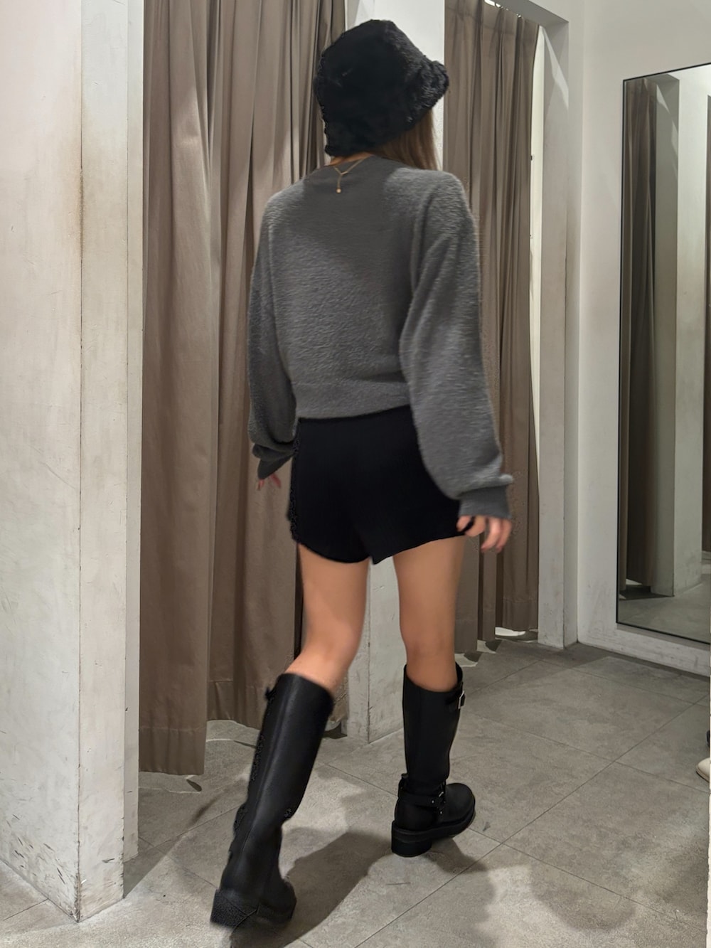 グレー系のニット/セーター、ブラック系のその他パンツ、ブラック系のブーツを着用したレディースの秋コーディネートの3枚目の写真