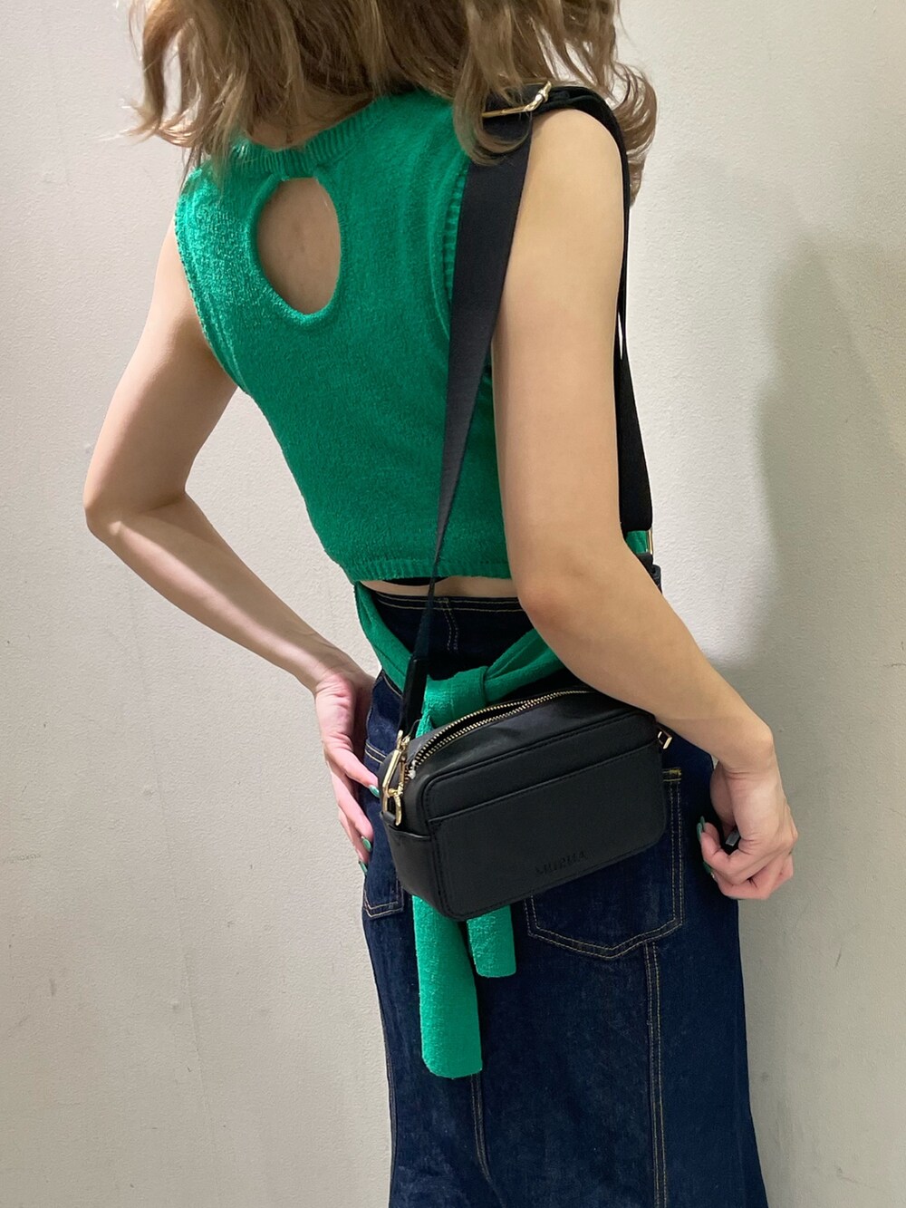 ブラック系のサンダル、ブラック系のショルダーバッグ、グリーン系のタンクトップを着用したレディースの夏コーディネートの8枚目の写真