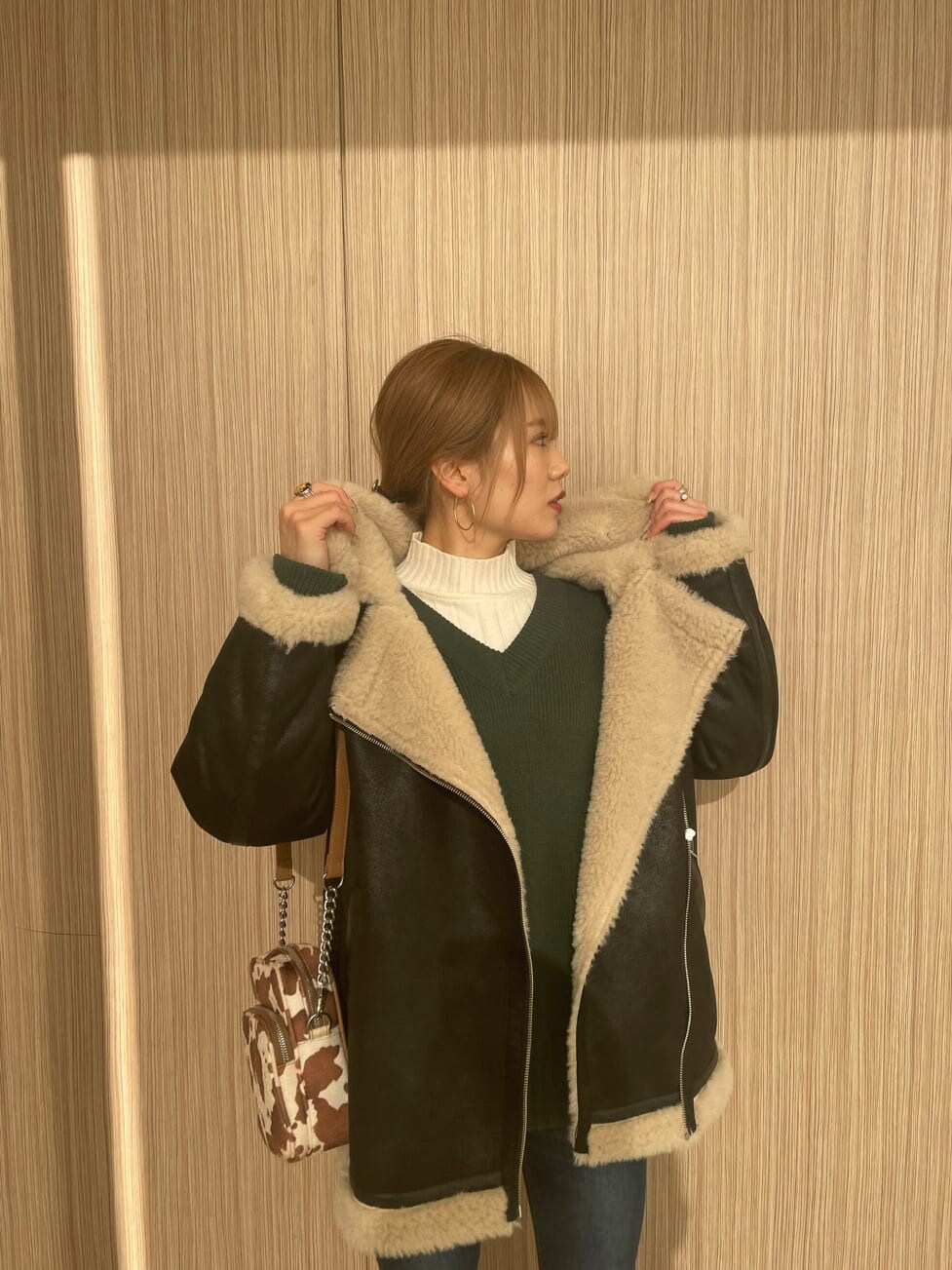 その他のハンドバッグ、ブラック系のブルゾン、ブラック系のブーツを着用したレディースの冬コーディネートの5枚目の写真