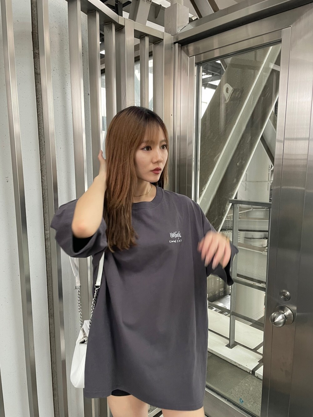 グレー系のTシャツ/カットソー、ホワイト系のハンドバッグを着用したレディースの春コーディネートの4枚目の写真