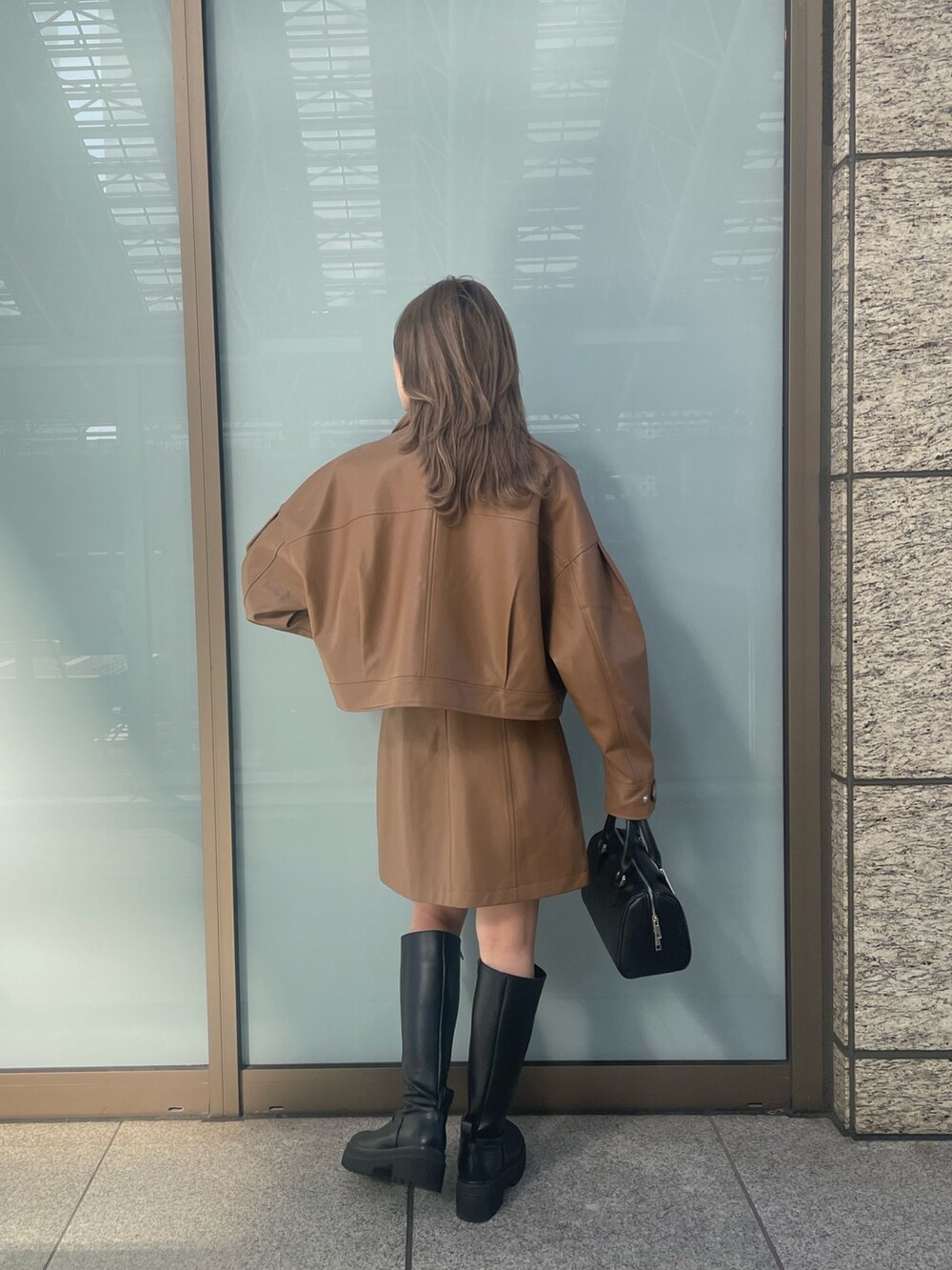 ブラック系のニット/セーター、ブラウン系のワンピース、イエロー系のブルゾンを着用したレディースの冬コーディネートの6枚目の写真