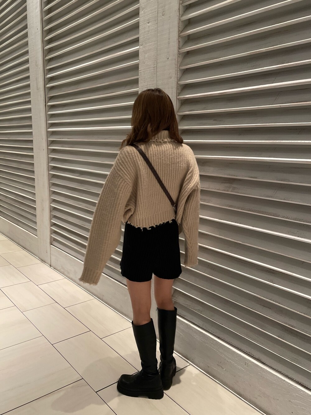 ホワイト系のニット/セーター、ブラック系のブーツ、その他のショルダーバッグを着用したレディースの秋コーディネートの3枚目の写真