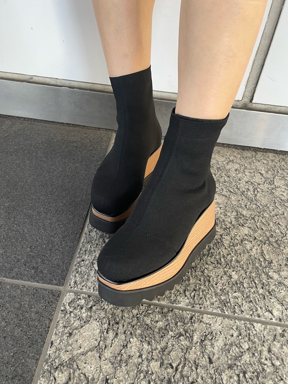 グリーン系のワンピース、ブラック系のショルダーバッグ、ブラック系のブーツを着用したレディースの秋コーディネートの8枚目の写真