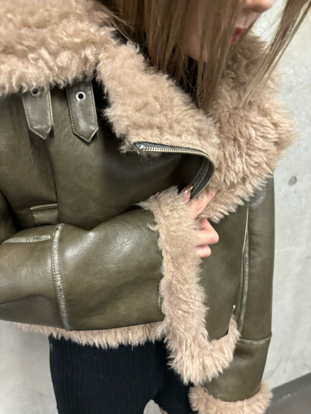 ブラック系のその他パンツ、ブラック系のブーツ、グリーン系のムートンコートを着用したレディースの夏コーディネートの7枚目の写真