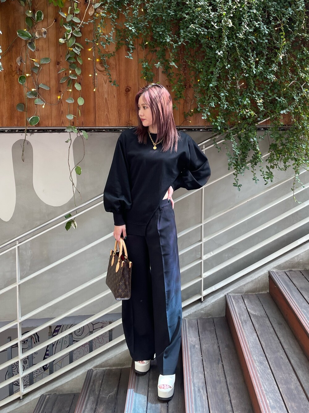 ブラック系のTシャツ/カットソー、ブラック系のスラックス、ホワイト系のサンダルを着用したレディースの春コーディネートの2枚目の写真