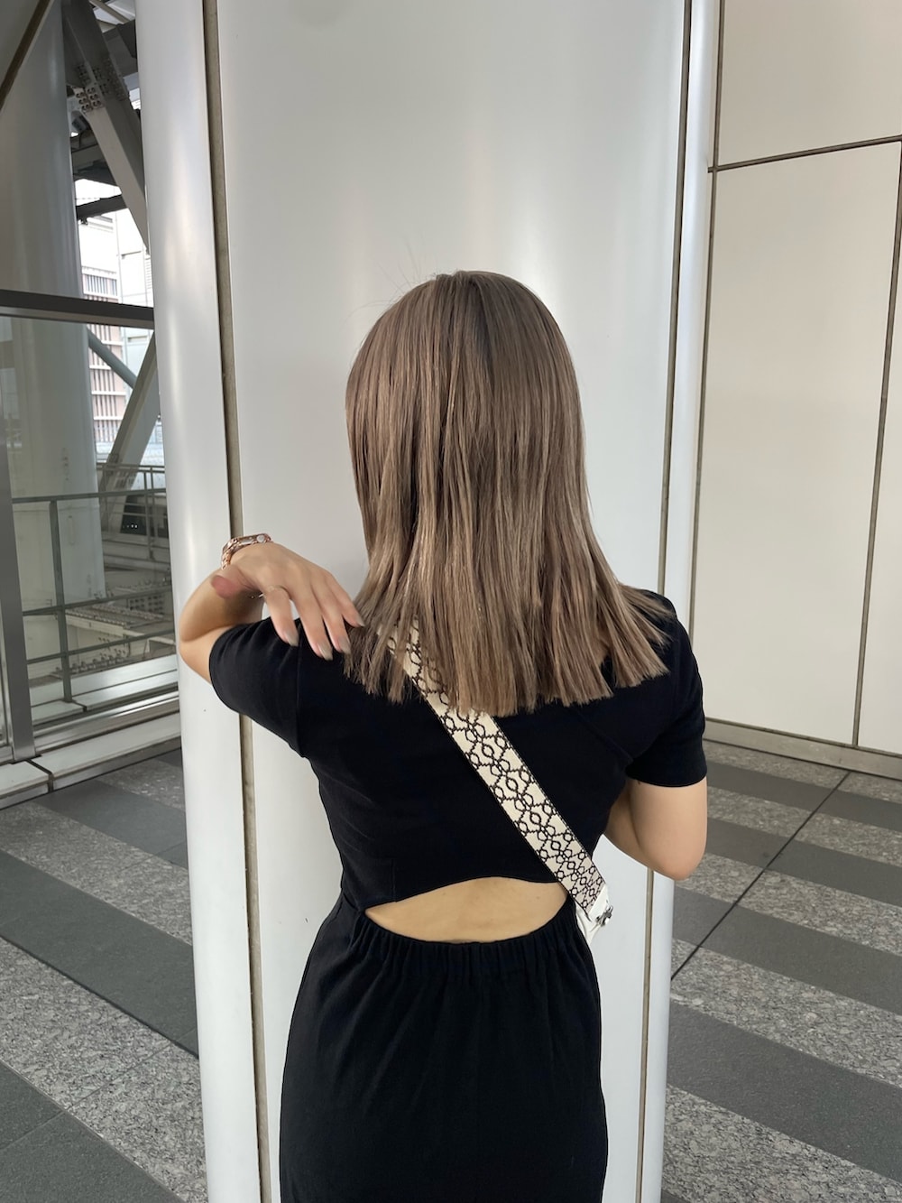 ブラック系のワンピース、ブラック系のサンダル、ホワイト系のショルダーバッグを着用したレディースの夏コーディネートの6枚目の写真