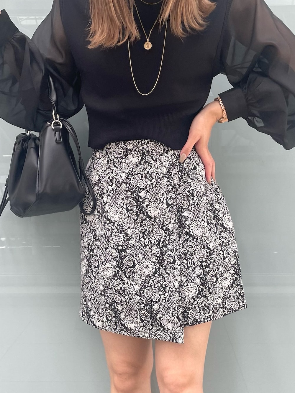 ブラック系のニット/セーター、ブラック系のブーツ、ブラック系のスカートを着用したレディースの夏コーディネートの8枚目の写真