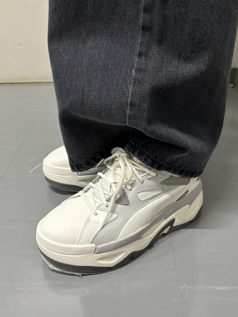 ブラック系のショルダーバッグ、グリーン系のニット/セーター、ブラック系のデニムパンツを着用したレディースの春コーディネートの10枚目の写真