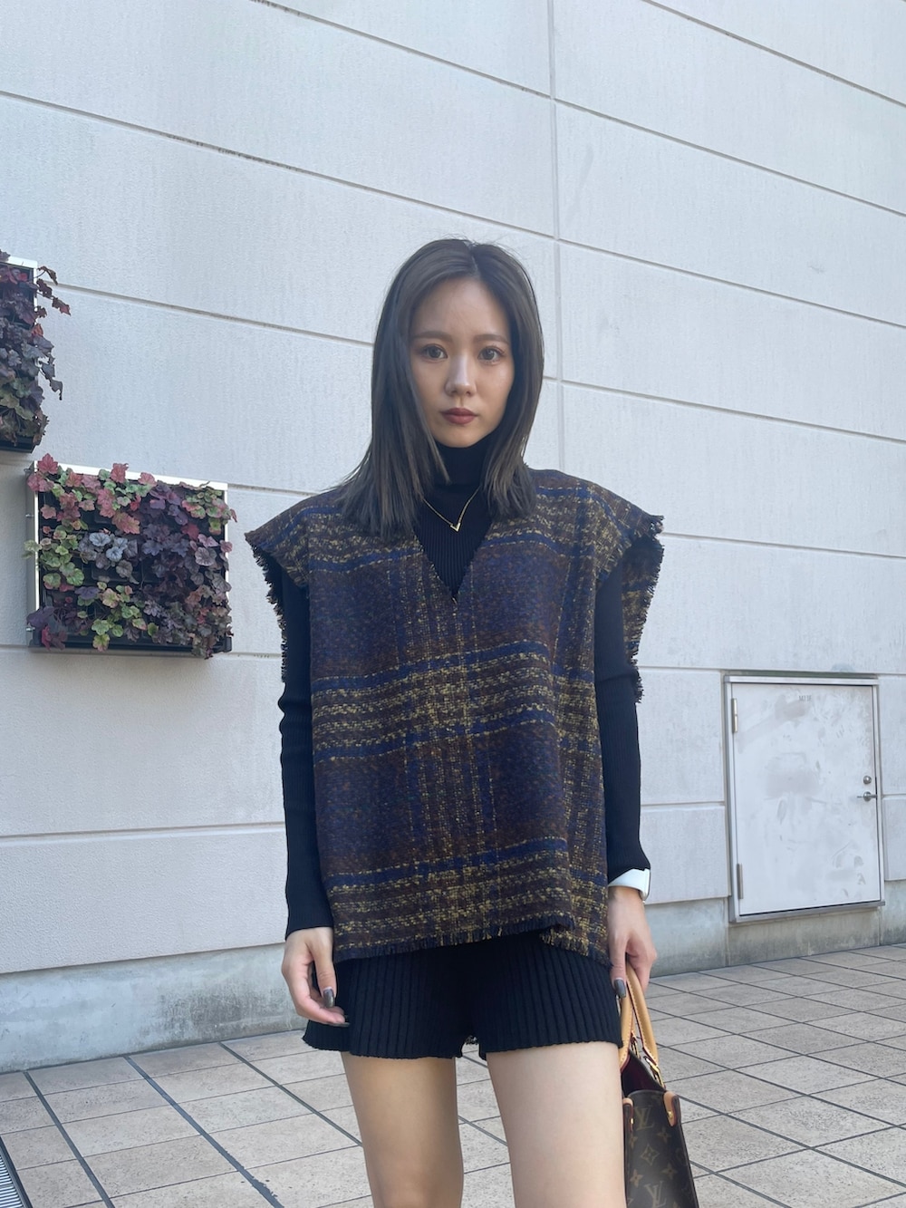 ブラック系のニット/セーター、ブラック系のその他パンツ、ブラウン系のワンピースを着用したレディースの秋コーディネートの5枚目の写真