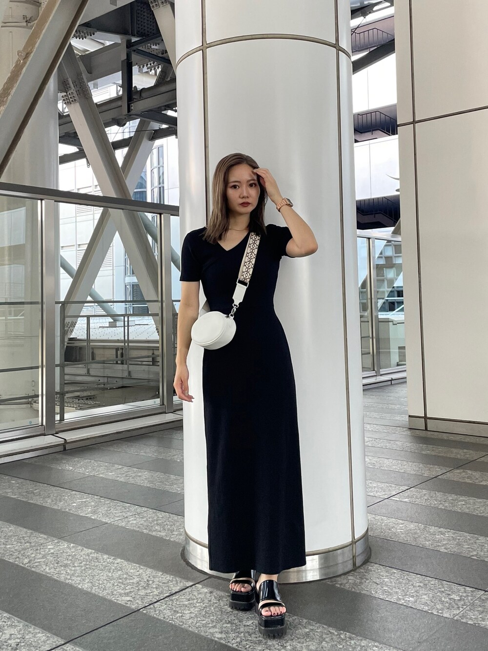ブラック系のワンピース、ブラック系のサンダル、ホワイト系のショルダーバッグを着用したレディースの夏コーディネートの3枚目の写真