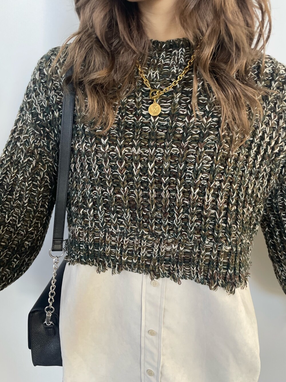 グリーン系のワンピース、ブラック系のショルダーバッグ、ブラック系のブーツを着用したレディースの秋コーディネートの6枚目の写真