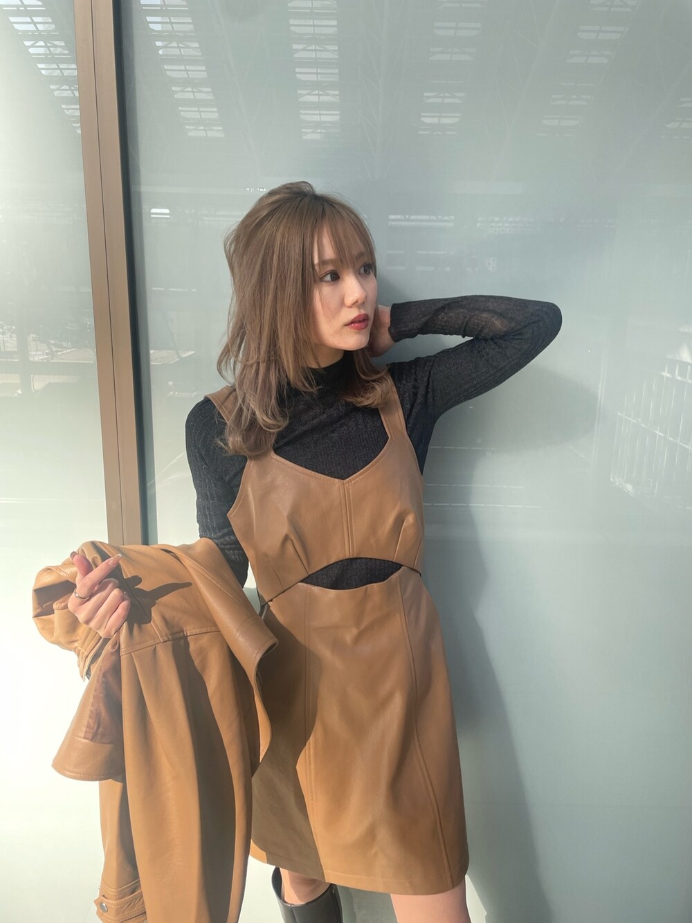 ブラック系のニット/セーター、ブラウン系のワンピース、イエロー系のブルゾンを着用したレディースの冬コーディネートの4枚目の写真