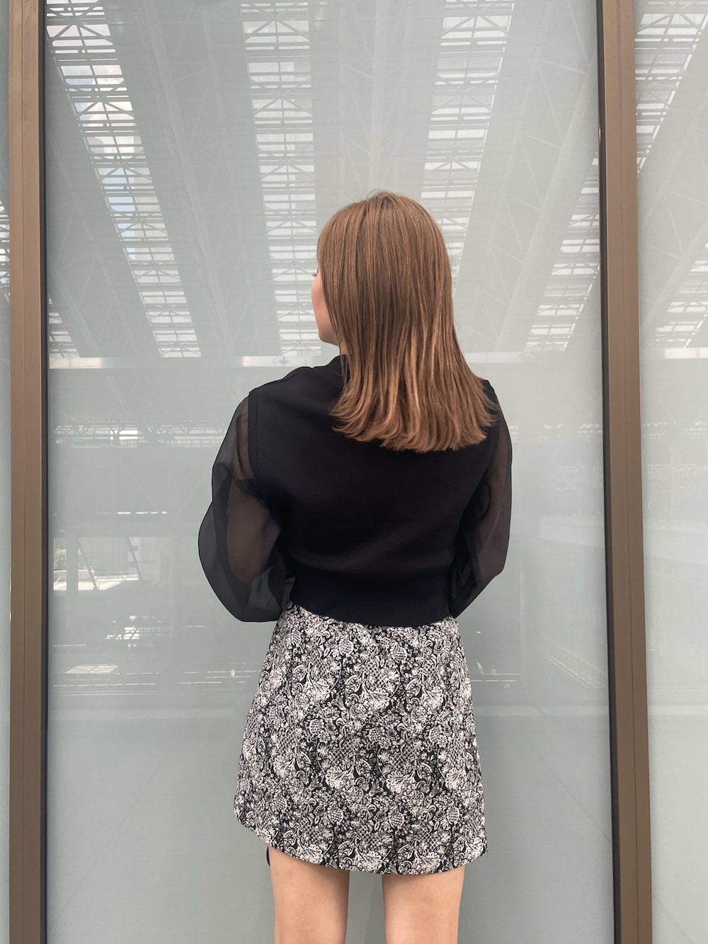 ブラック系のニット/セーター、ブラック系のブーツ、ブラック系のスカートを着用したレディースの夏コーディネートの7枚目の写真