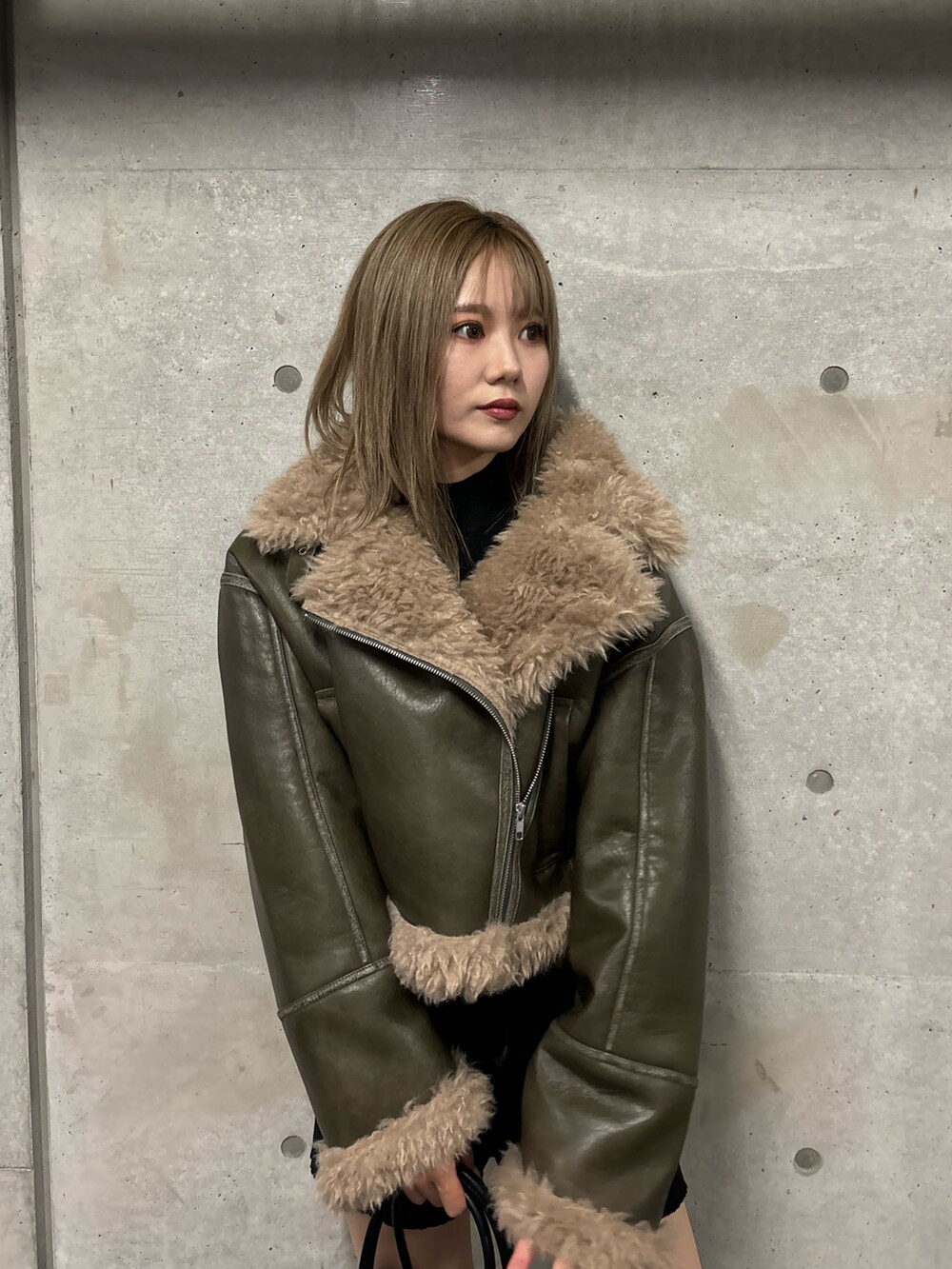 ブラック系のその他パンツ、ブラック系のブーツ、グリーン系のムートンコートを着用したレディースの夏コーディネートの6枚目の写真