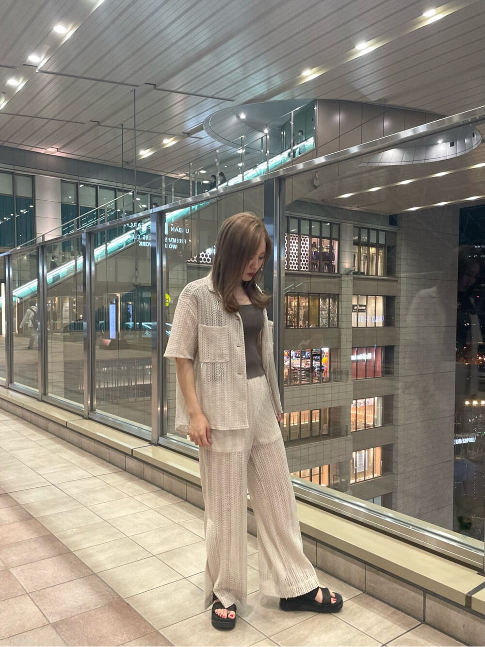 ベージュ系のタンクトップ、ホワイト系のスウェットパンツ、ホワイト系のシャツ/ブラウスを着用したレディースの春コーディネートの2枚目の写真