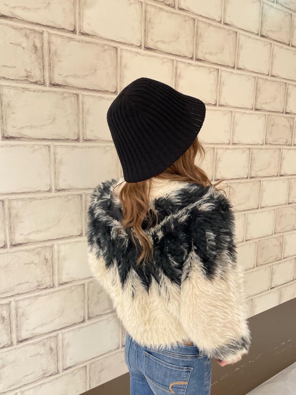 ホワイト系のニット/セーター、ブラウン系のブーツ、ブラック系のハットを着用したレディースの秋コーディネートの6枚目の写真