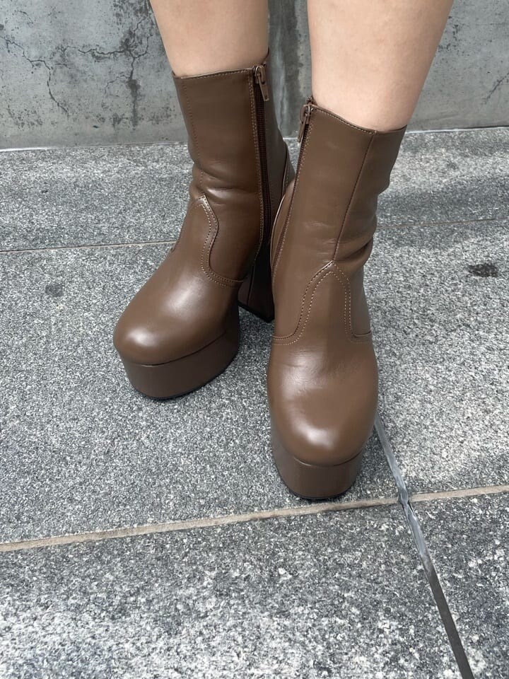 ブラウン系のスカート、ベージュ系のブーツ、パープル系のカーディガン/ボレロを着用したレディースの秋コーディネートの9枚目の写真