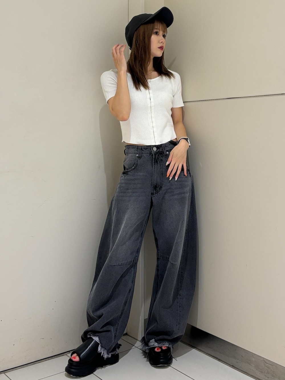 ブラック系のサンダル、ブラック系のデニムパンツ、ホワイト系のニット/セーターを着用したレディースの夏コーディネートの3枚目の写真