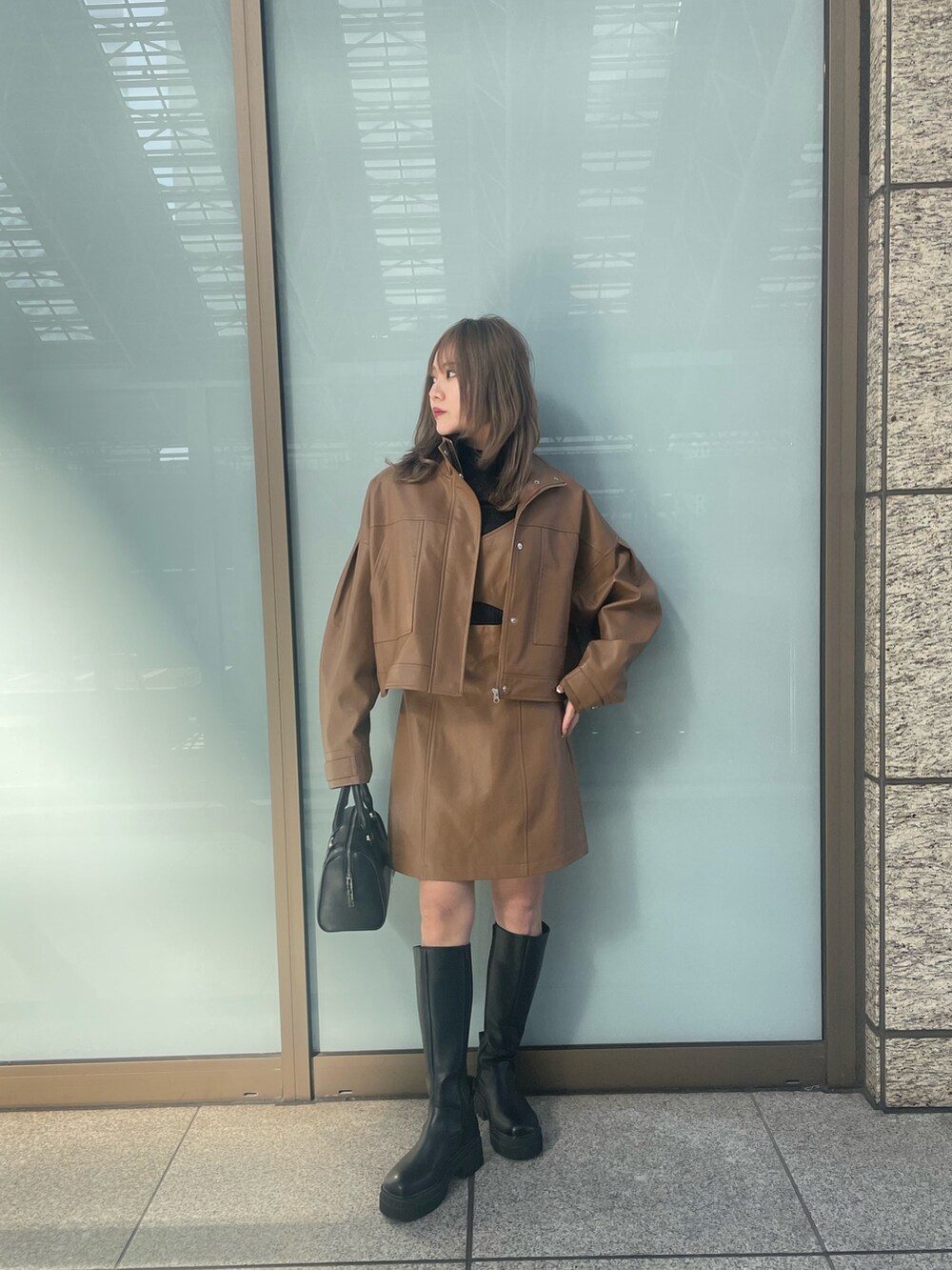 ブラック系のニット/セーター、ブラウン系のワンピース、イエロー系のブルゾンを着用したレディースの冬コーディネートの5枚目の写真