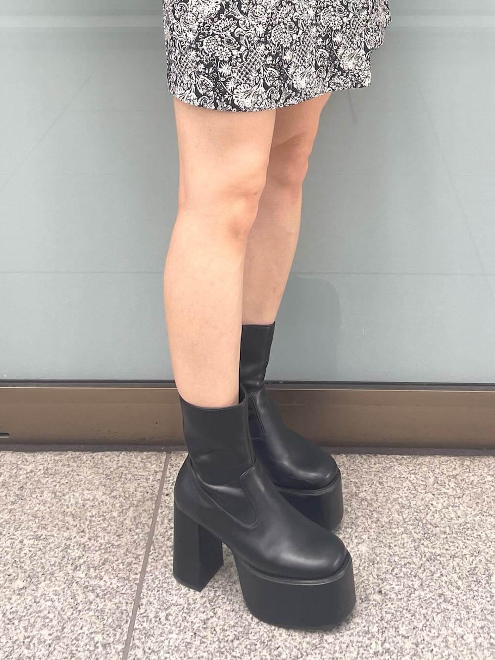 ブラック系のニット/セーター、ブラック系のブーツ、ブラック系のスカートを着用したレディースの夏コーディネートの9枚目の写真