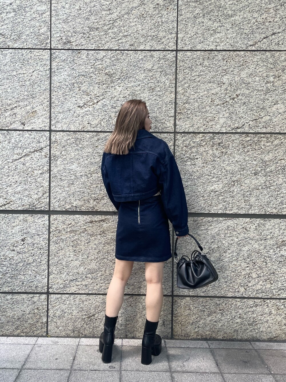 ベージュ系のニット/セーター、ブルー系のスカート、ブラック系のブーツを着用したレディースの夏コーディネートの4枚目の写真