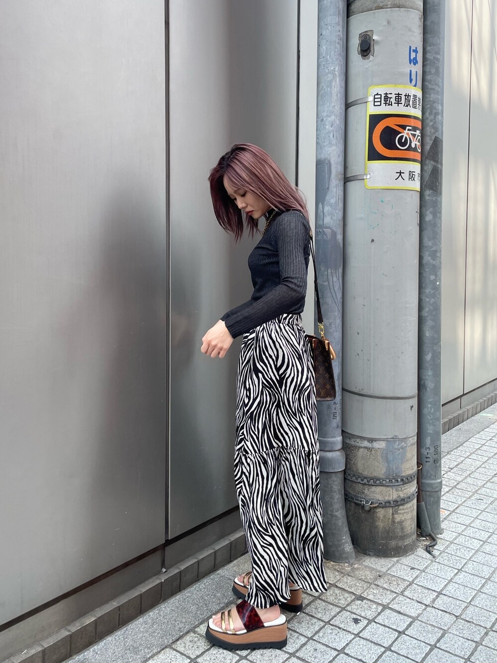 ブラック系のニット/セーター、ホワイト系のスカート、その他のサンダルを着用したレディースの春コーディネートの4枚目の写真