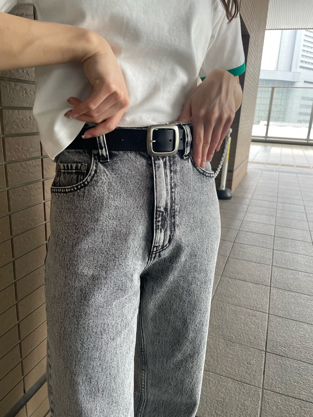 ホワイト系のTシャツ/カットソー、グレー系のデニムパンツを着用したレディースの春コーディネートの7枚目の写真