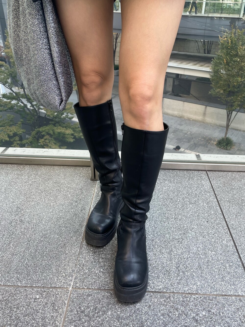 ホワイト系のスウェット、ブラック系のブーツ、ブラック系のハットを着用したレディースの秋コーディネートの8枚目の写真