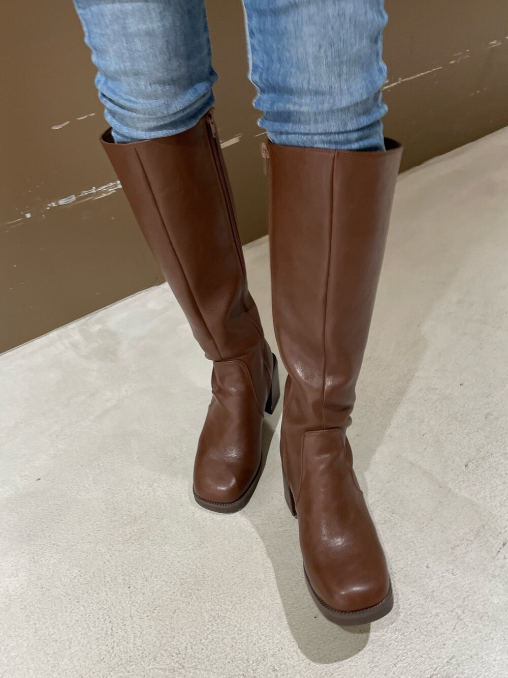 ホワイト系のニット/セーター、ブラウン系のブーツ、ブラック系のハットを着用したレディースの秋コーディネートの8枚目の写真