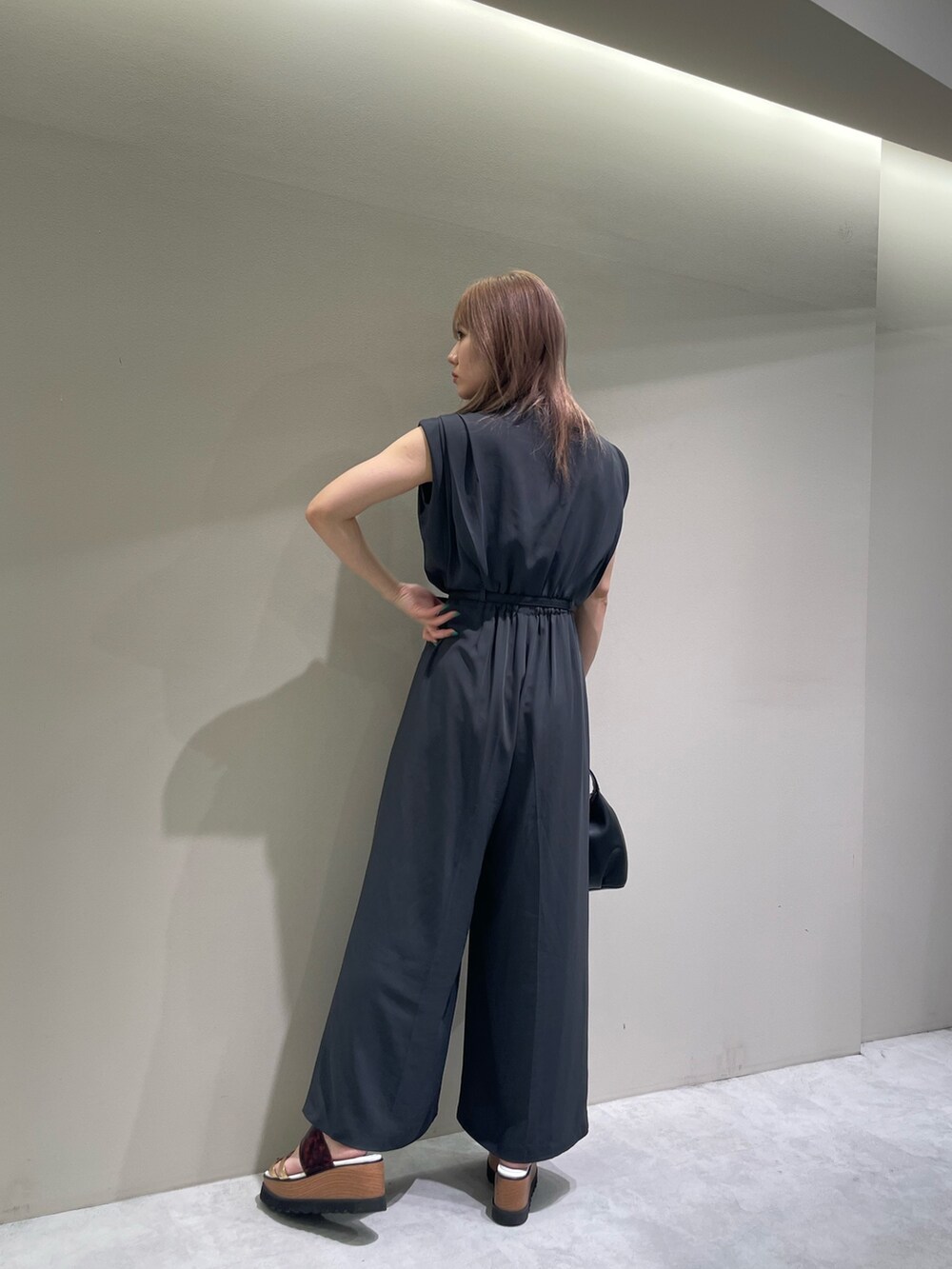 グレー系のつなぎ/オールインワン、その他のサンダル、ブラック系のハンドバッグを着用したレディースの夏コーディネートの2枚目の写真