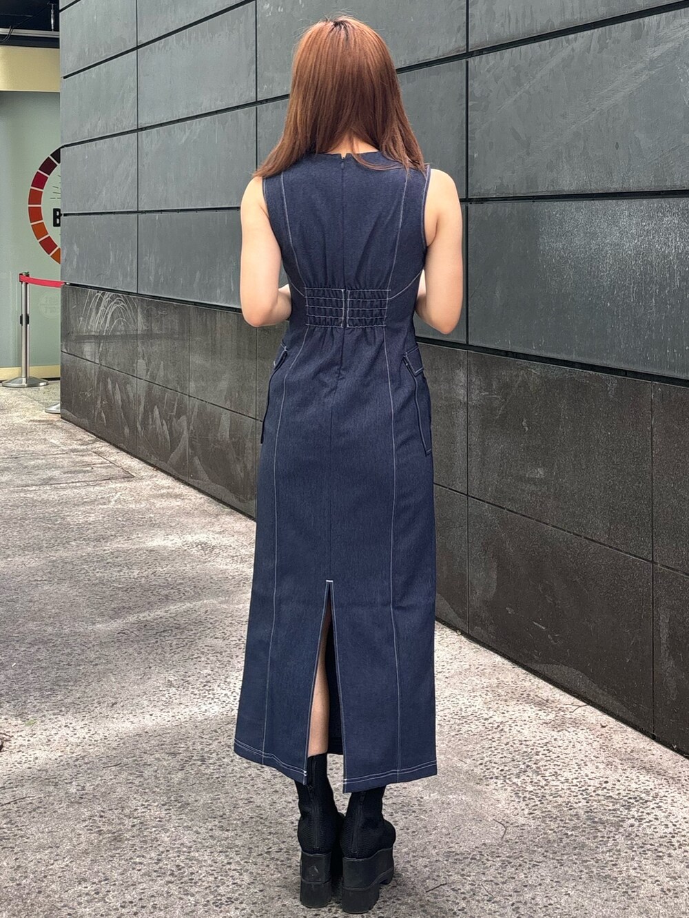 ブルー系のワンピース、ブラック系のブーツを着用したレディースの春コーディネートの2枚目の写真