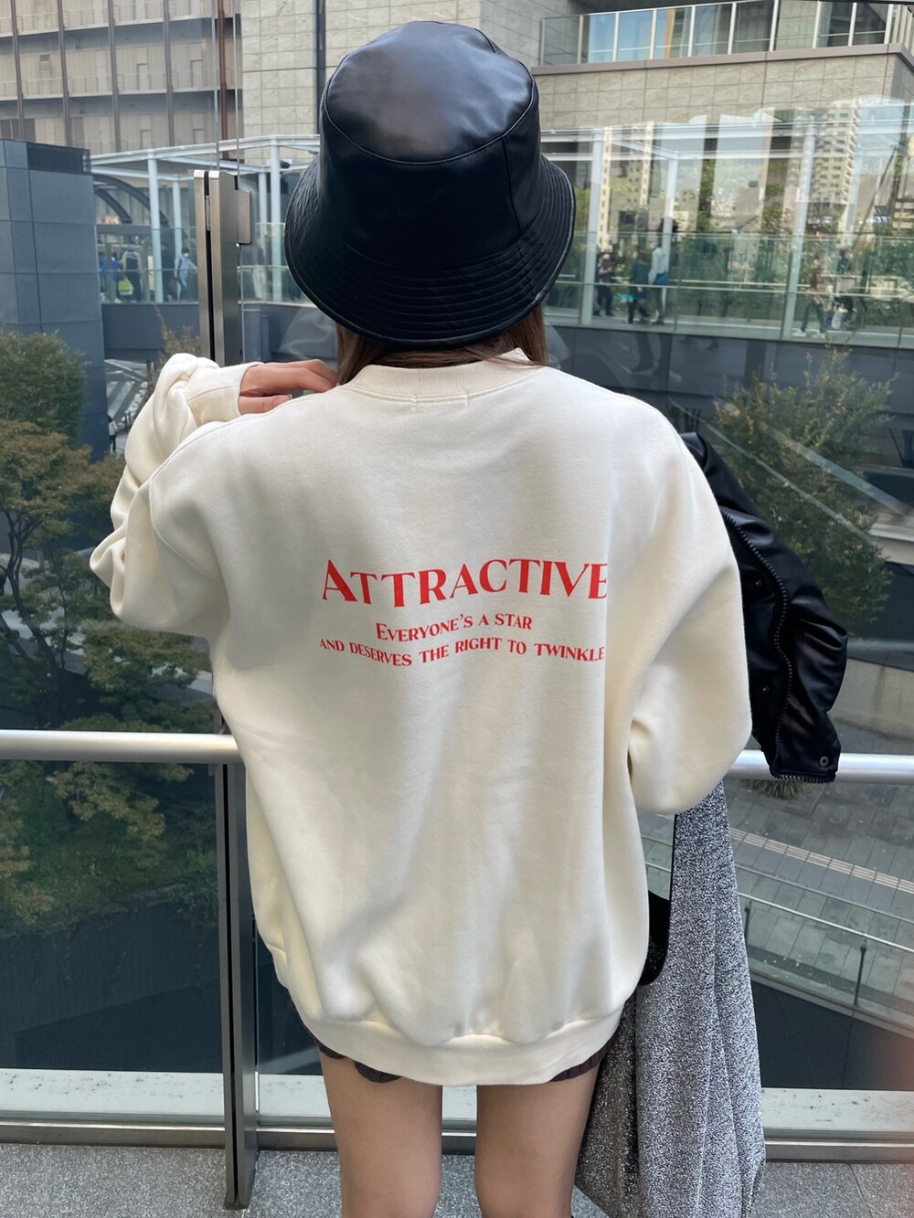 ホワイト系のスウェット、ブラック系のブーツ、ブラック系のハットを着用したレディースの秋コーディネートの3枚目の写真