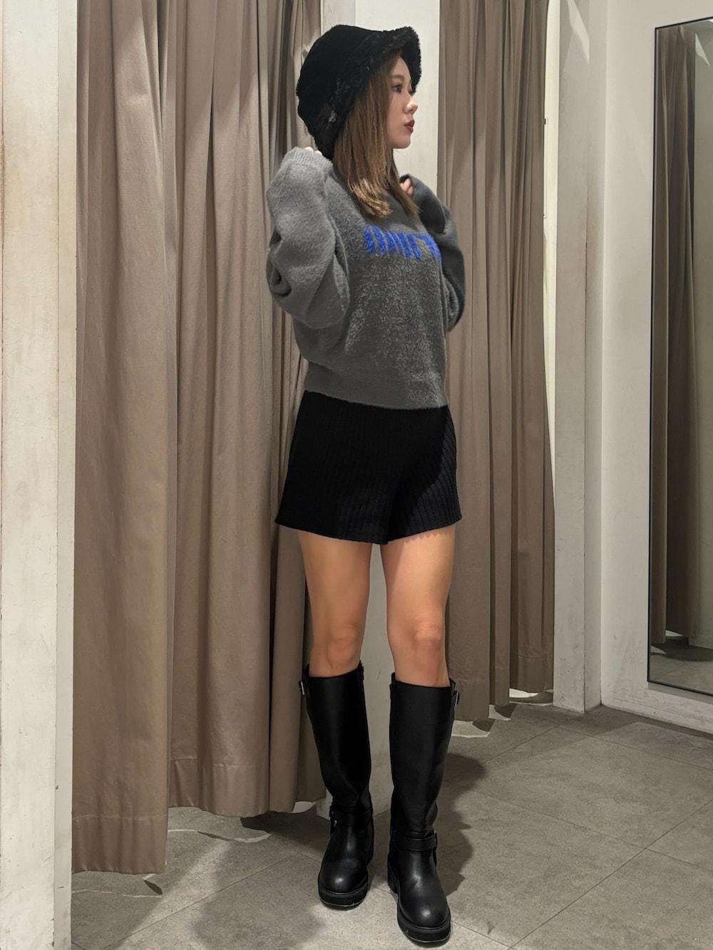 グレー系のニット/セーター、ブラック系のその他パンツ、ブラック系のブーツを着用したレディースの秋コーディネートの4枚目の写真