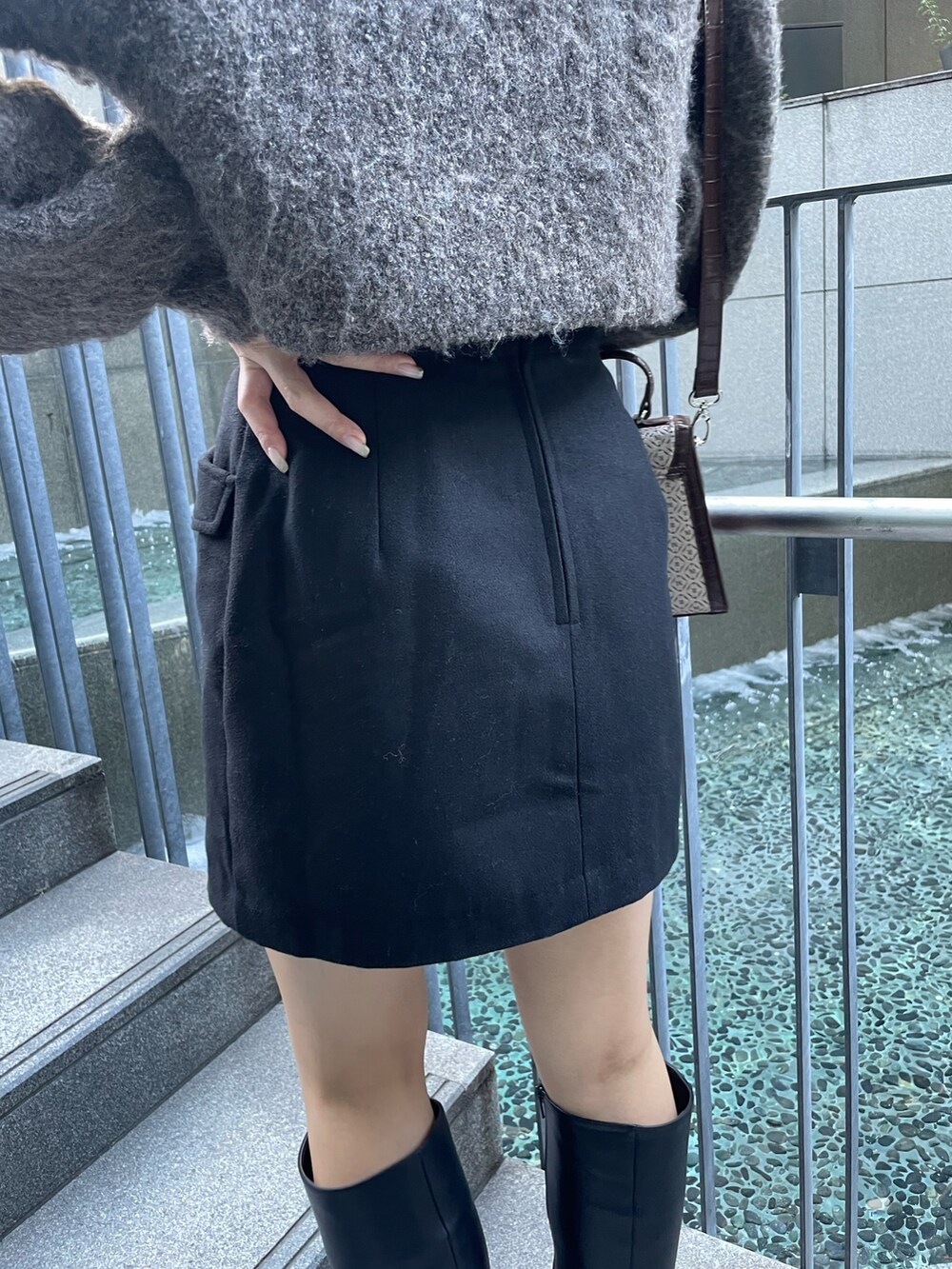 ブラウン系のニット/セーター、ブラック系のスカート、その他のハンドバッグを着用したレディースの秋コーディネートの8枚目の写真