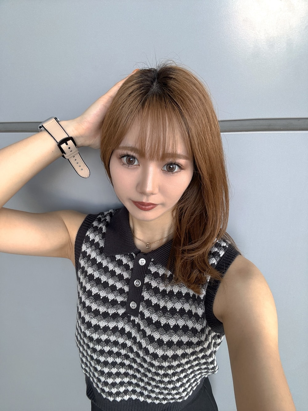 グレー系のニット/セーター、シルバー系のハンドバッグ、ブラック系のスカートを着用したレディースの夏コーディネートの6枚目の写真