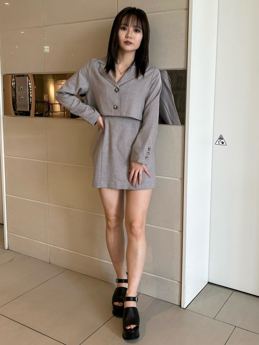 ブラック系のサンダル、グレー系のワンピースを着用したレディースの春コーディネートの2枚目の写真