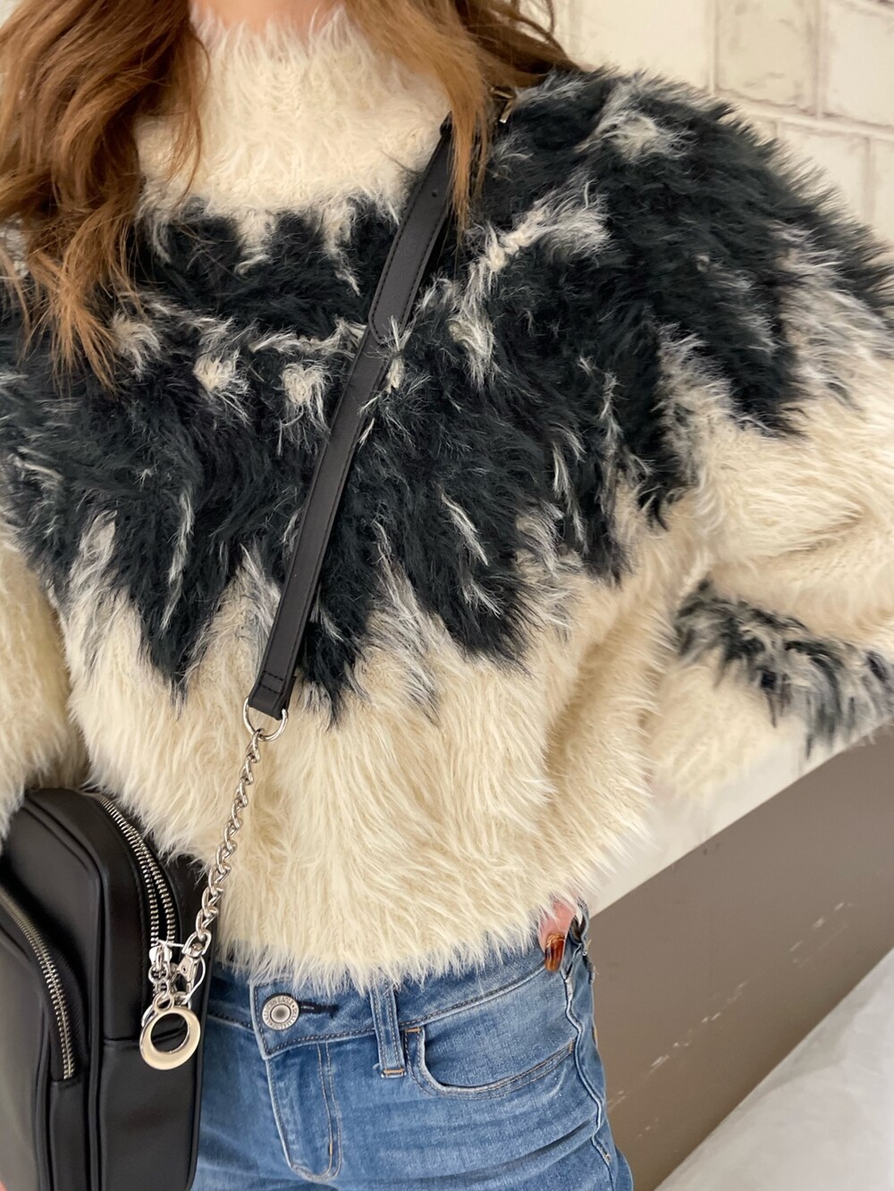 ホワイト系のニット/セーター、ブラウン系のブーツ、ブラック系のハットを着用したレディースの秋コーディネートの7枚目の写真