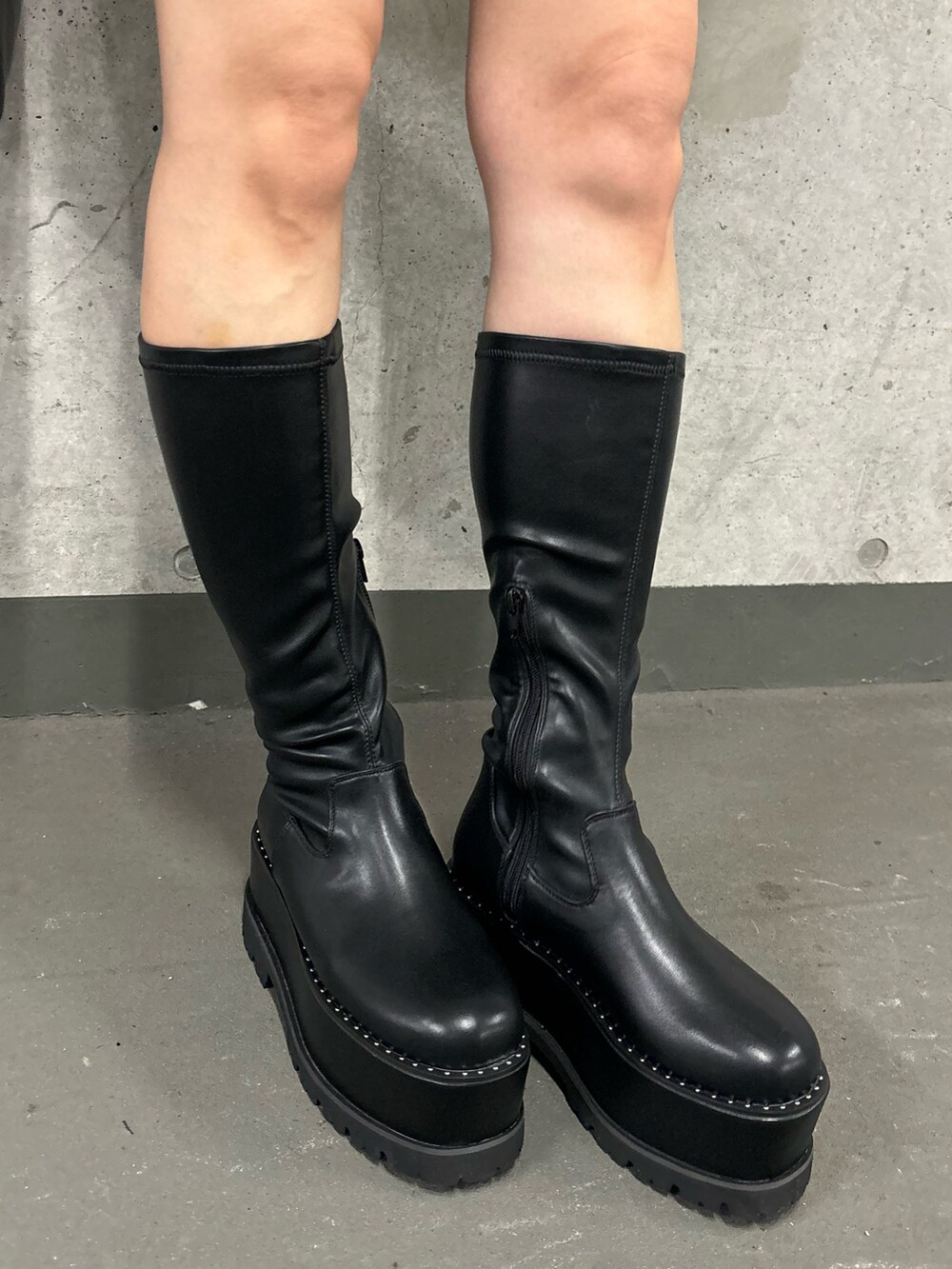 ブラック系のその他パンツ、ブラック系のブーツ、グリーン系のムートンコートを着用したレディースの夏コーディネートの9枚目の写真